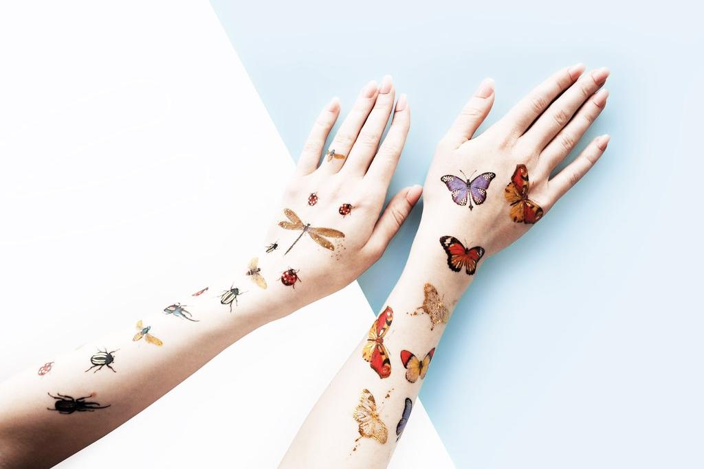 Zwei Arme mit Schmetterlingstattoos von PAPERSELF