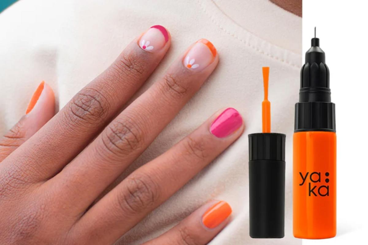 Eine Nahaufnahme einer Hand auf einem Pullover. Die Nägeln sind mit Nail Art bzw. Mustern in drei verschiedenen Nagellackfarben verziert. Rechts daneben ist der Nagellackstift abgebildet, der einen Pinsel und einen Fineliner enthält.